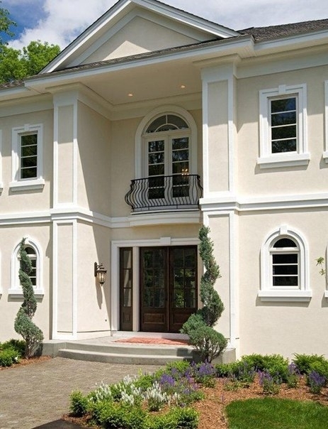 Фасад дома в классическом стиле выглядит торжественно.