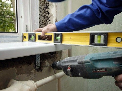 На фото - процедура контроля при помощи уровня