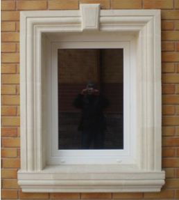 Обрамление окна на фасаде дома натуральным камнем